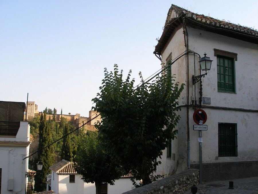 Calle empedrada del Albaicín con la Alhambra al fondo