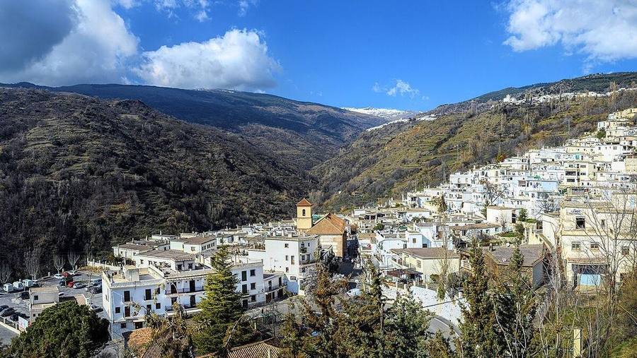 Pueblo blanco de Pampaneira en la Alpujarra con Sierra Nevada al fondo